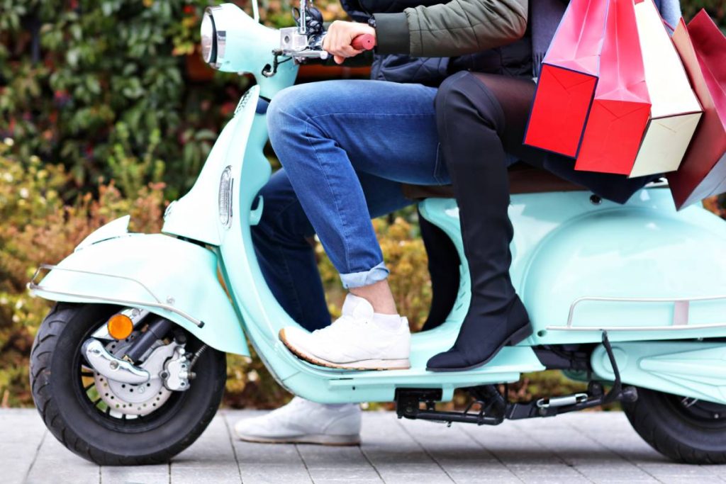 Portrait of happy couple with shopping bags after shopping in city smiling and huging